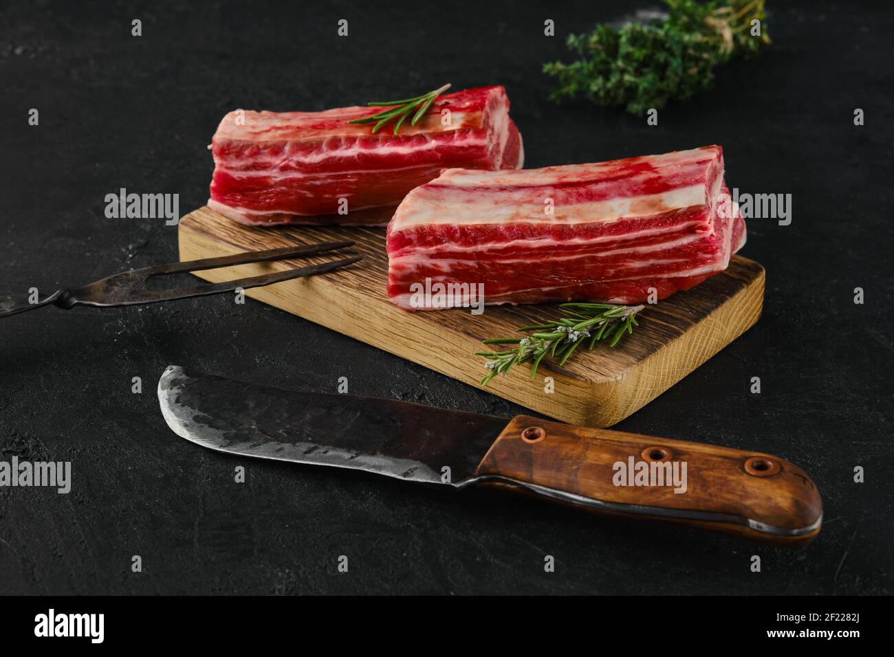 Raw beef short ribs, bone in on dark background Stock Photo