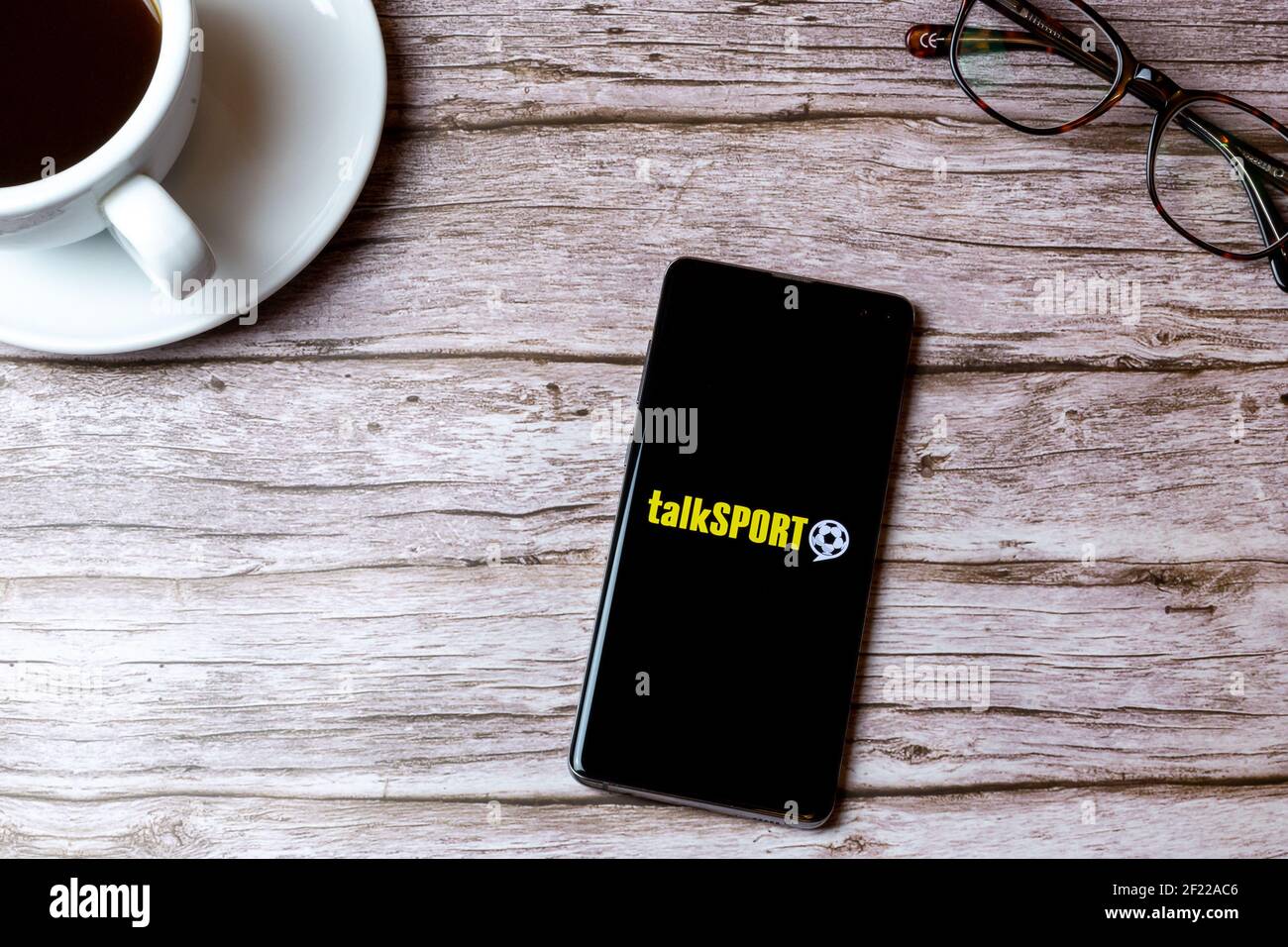 A mobile phone or cell phone laid on a wooden table with the talk sport ...