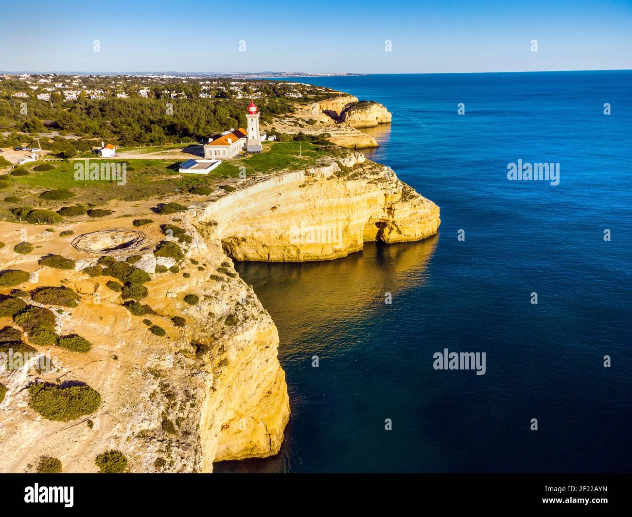 Cliffy coast of Algarve with Alfazinha Lighthouse in Carvoeiro, Portugal Stock Photo