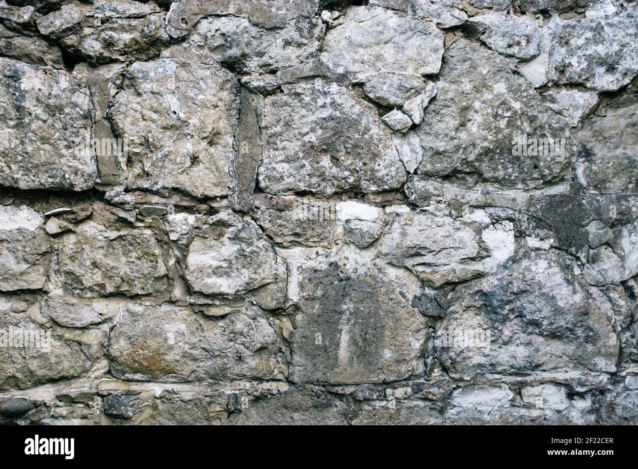 Grey stone granite wall with uneven textures Stock Photo
