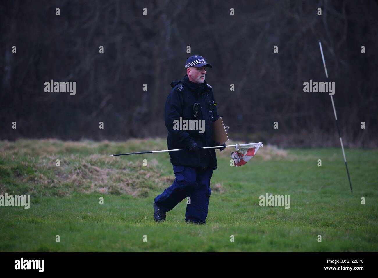 An officer from the Metropolitan Police carries a flag as he takes part in a search near to Great Chart Golf and Lesiure in Ashford, Kent. A serving Metropolitan Police officer has been arrested in Deal, Kent, in connection with the disappearance of Sarah Everard who has been missing for a week. The 33-year-old disappeared on Wednesday March 3 after leaving a friend's house in Clapham, south London, and began walking to her home in Brixton. Picture date: Wednesday March 10, 2021. Stock Photo