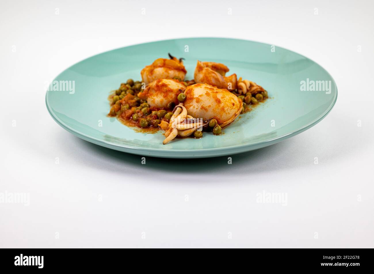 second course with cuttlefish and tomato peas on a white background ...