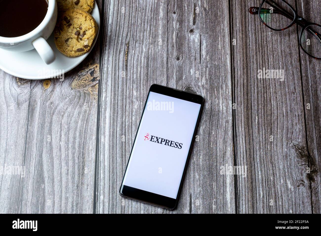 A mobile phone or cell phone laid on a wooden table with the express ...