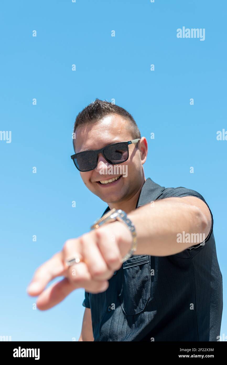 Happy man pointing fingers at camera on sky background. Stock Photo