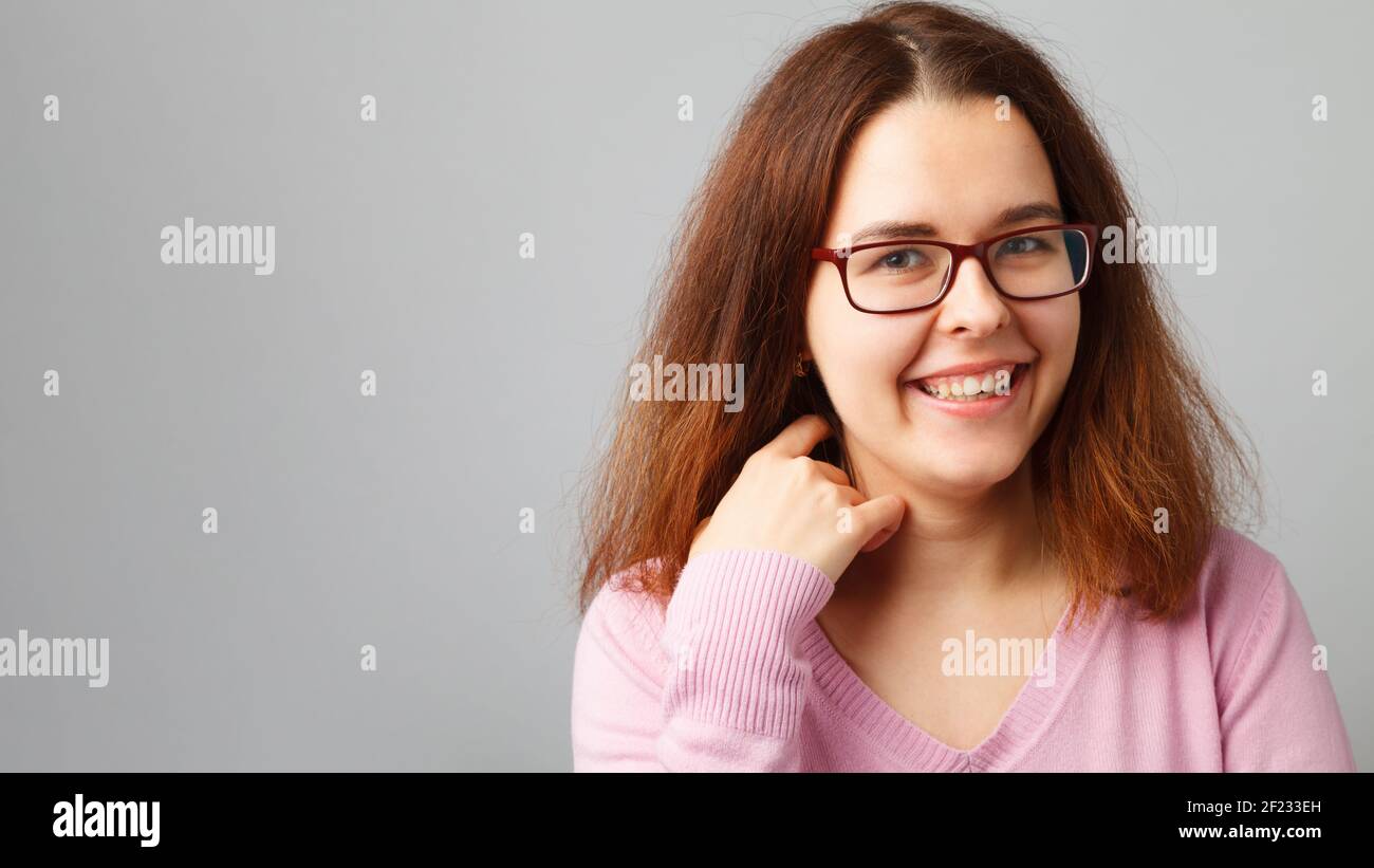 Young redhead woman wearing glasses. Head and shoulders portrait. Stock Photo