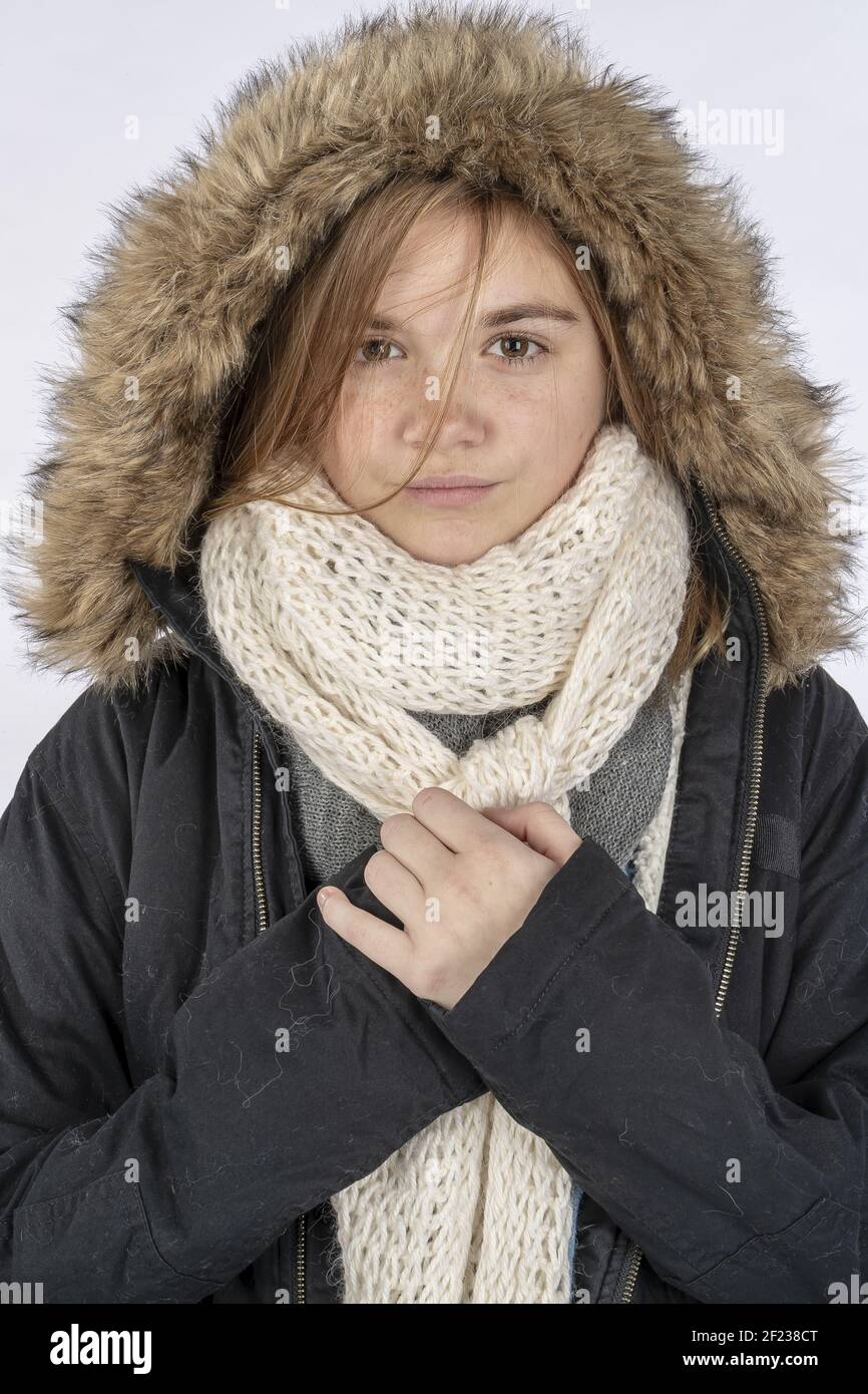Lovely Blonde Teenage Model Wearing A Winter Coat In a Studio Environment Stock Photo