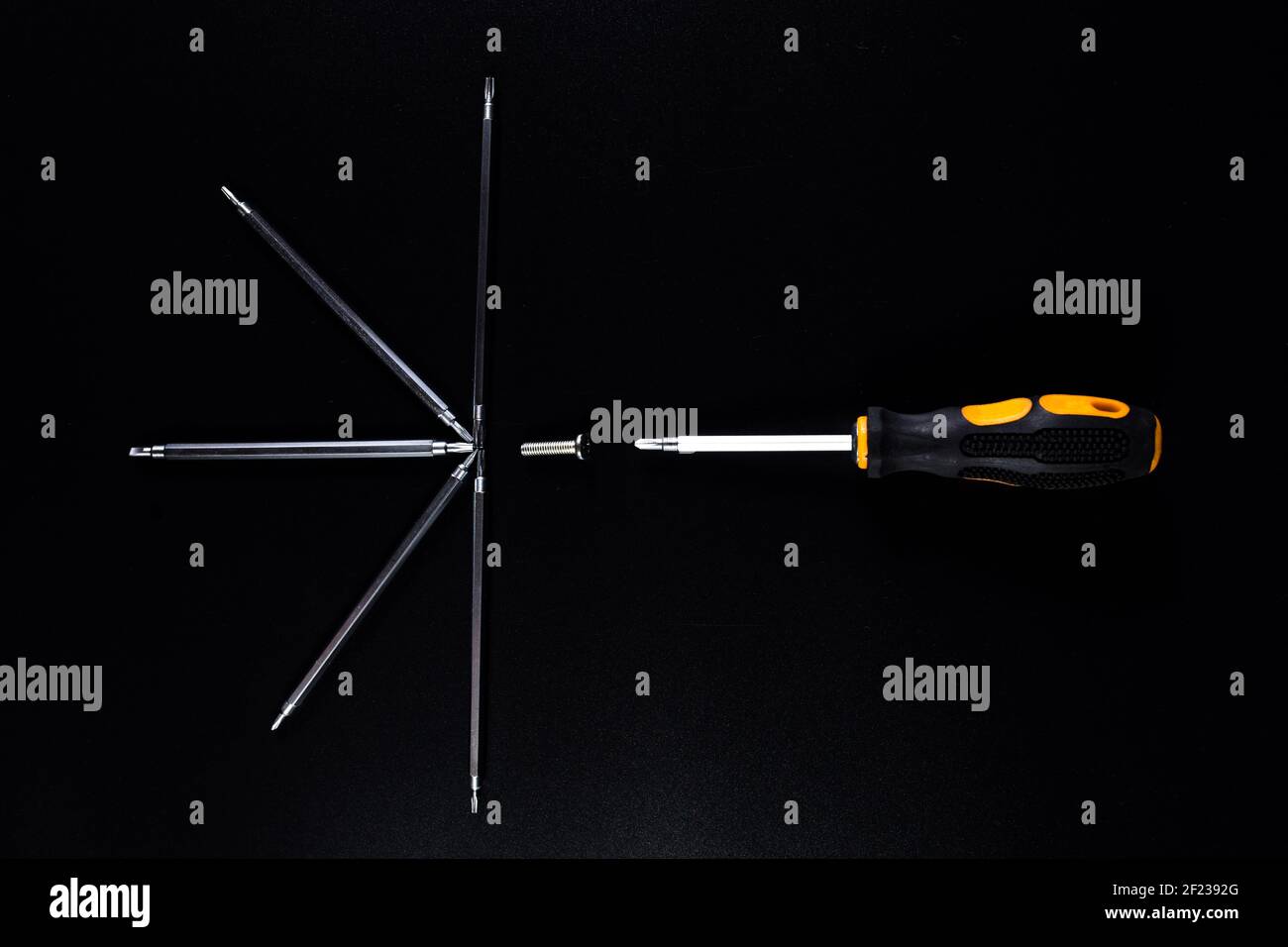 Kit of small screwdrivers on black background for reparing phones and other small electronics. Stock Photo