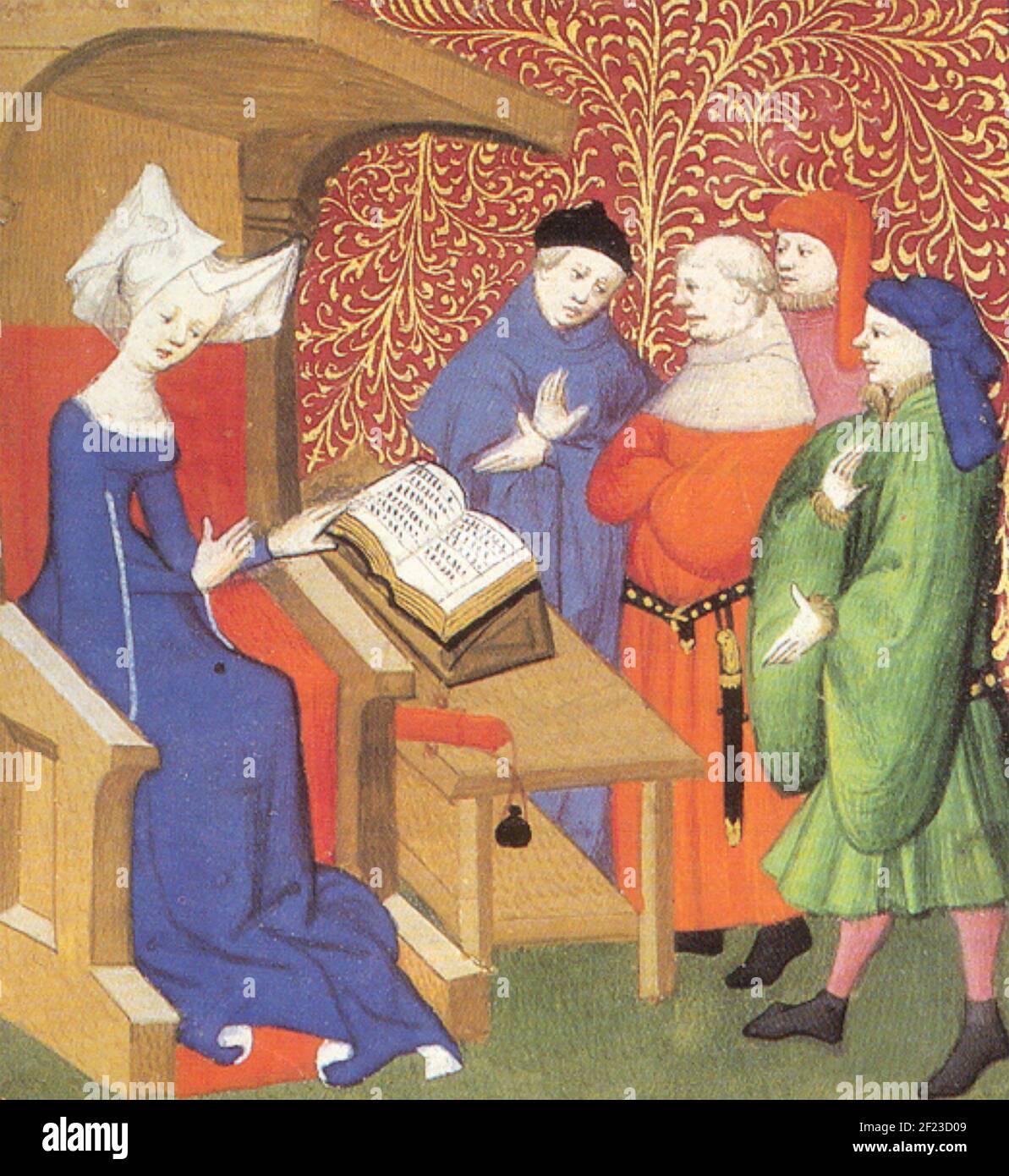 CHRISTINE de PIZAN (1364-c 1430) Venetian-French poet and author at the court of Charles VI of France here reading to a group of courtiers about 1413 Stock Photo