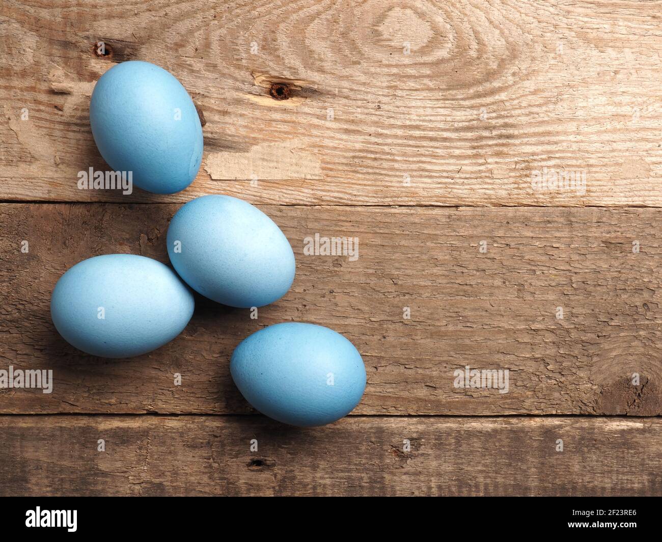 Naturally colored organic eggs on a rustic table with space for text, Easter background Stock Photo