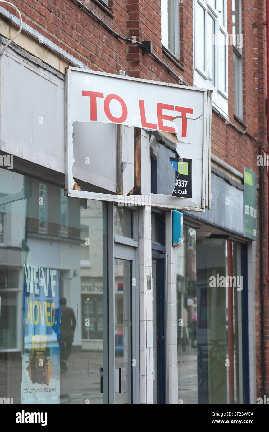 Damaged To Let sign over an empty retail shop premises in UK Stock Photo