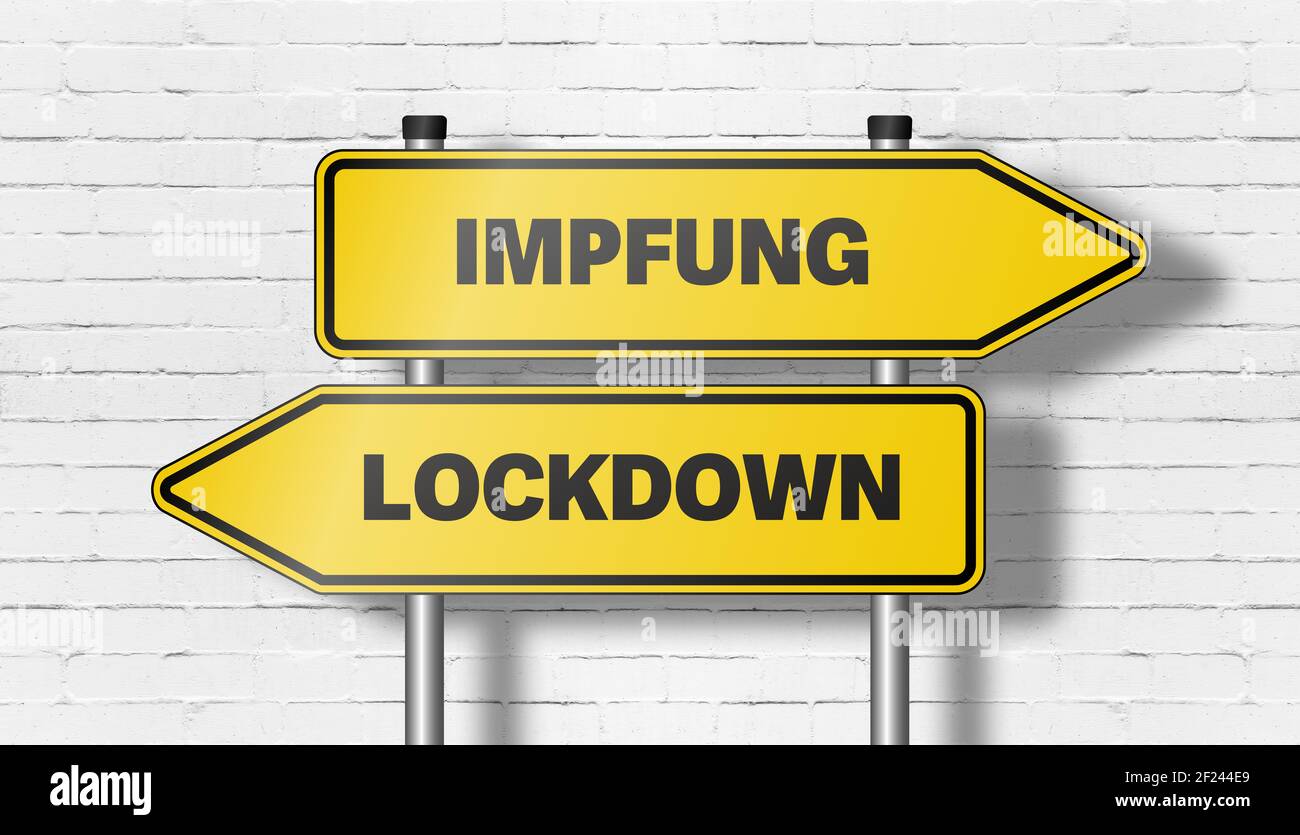 signpost with directional road signs pointing in both directions with words IMPFUNG, German for vaccination, and LOCKDOWN against wall Stock Photo