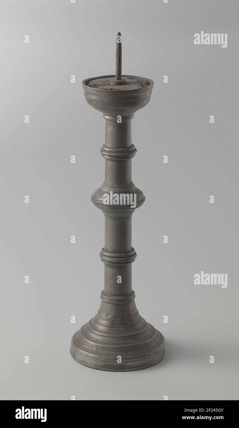 Kandelaar van tin met drie nodi en kaarsenpin.Candlestick of tin, from the  inside. The base is, with a wooden core, is at the bottom of a wide and  runs to the top