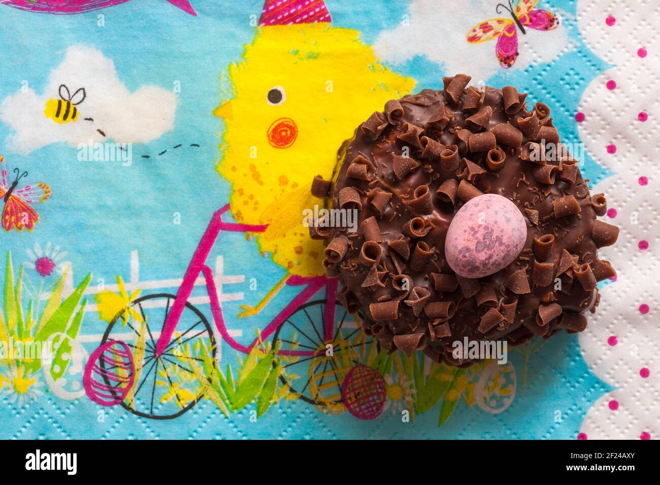 Cadbury Mini Eggs Nest Cake set on Easter serviette napkin Stock Photo