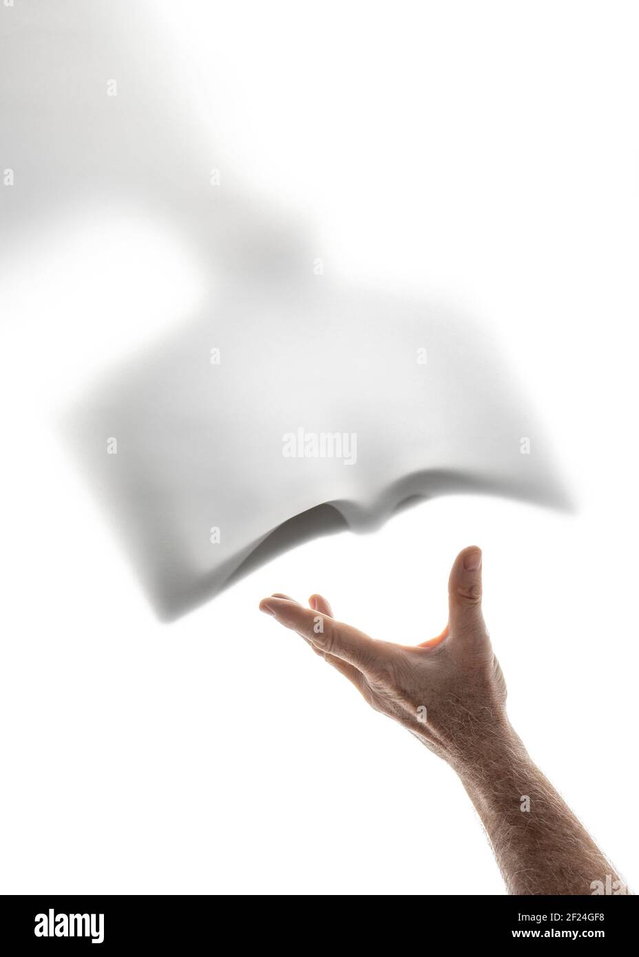 Human hand receiving the word of God brought by a heavenly messenger Stock Photo