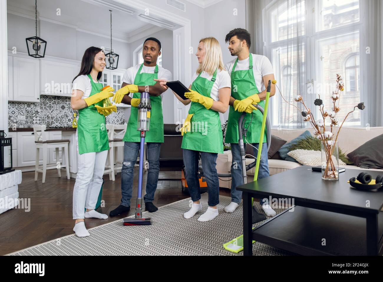 Multiracial team of cleaning service using digital tablet Stock Photo