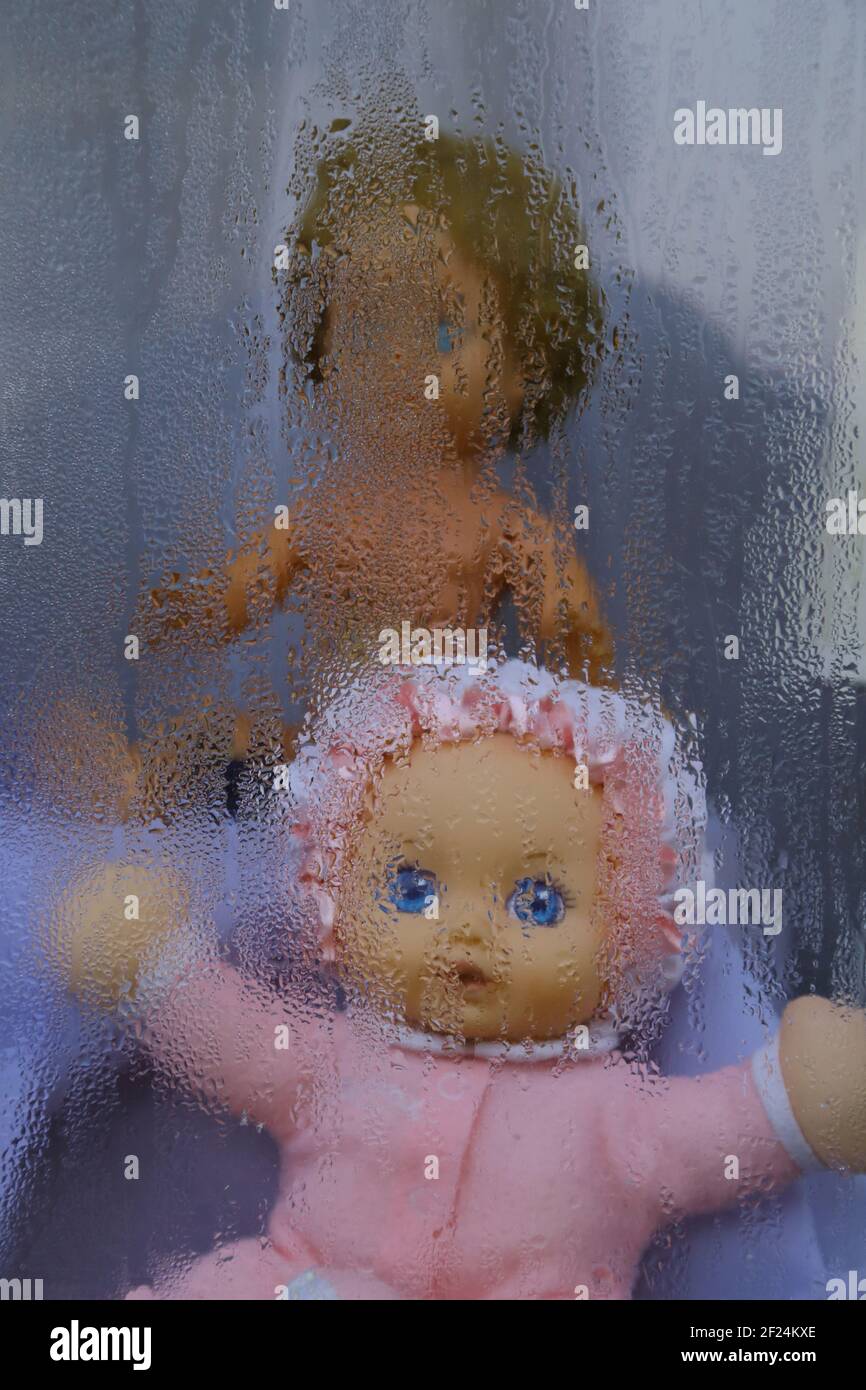 Dolls behind steamy window Stock Photo
