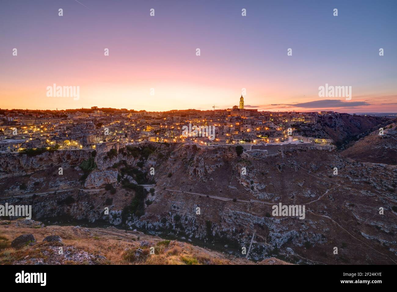 The beautiful old town of Matera and the canyon of the Gravina river after sunset Stock Photo