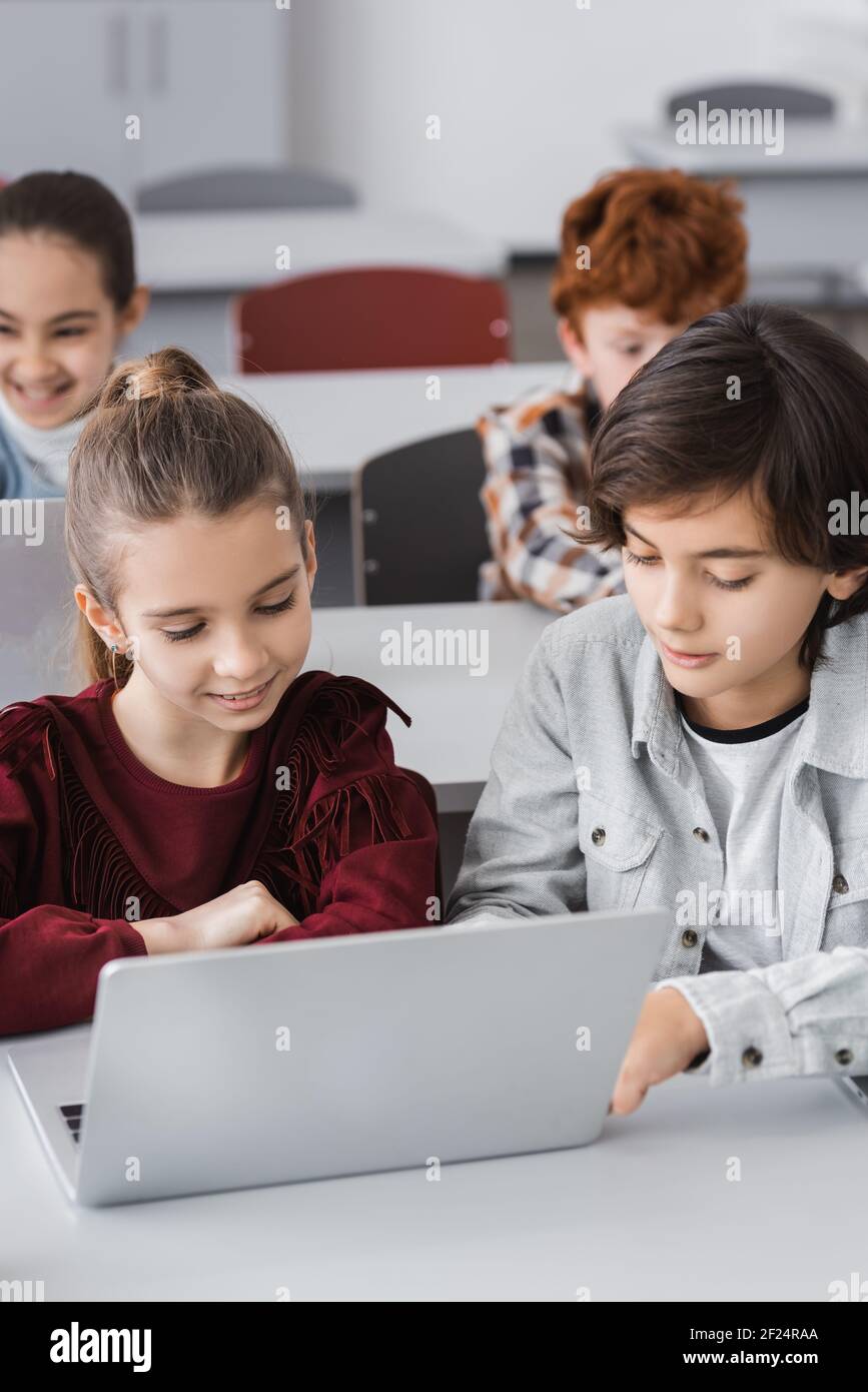 schoolchildren using laptops together during lesson in school Stock Photo