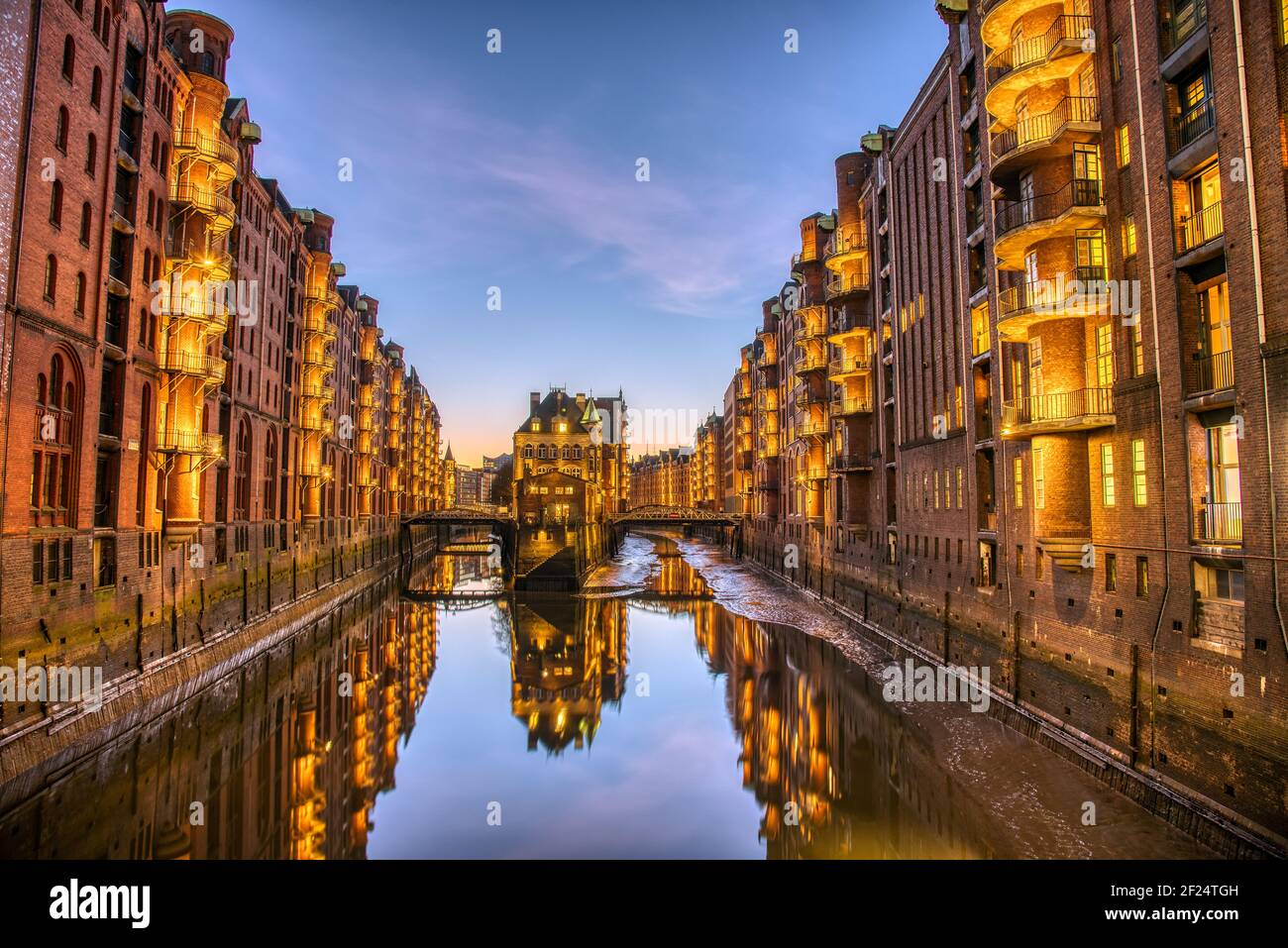 The old Speicherstadt with the Wasserschloss in Hamburg, Germany, at dusk Stock Photo