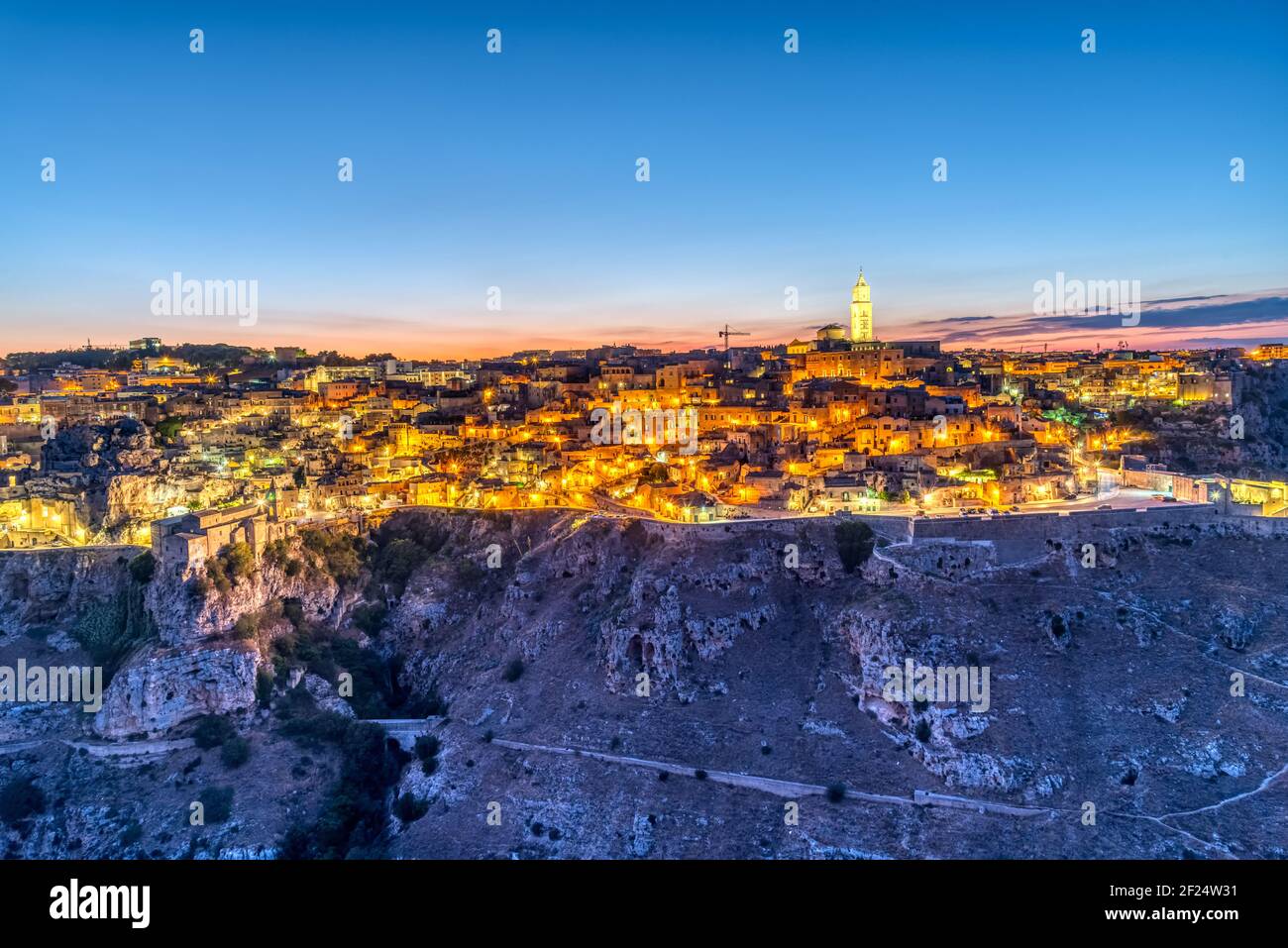 View of the beautiful old town of Matera and the canyon of the Gravina river after sunset Stock Photo