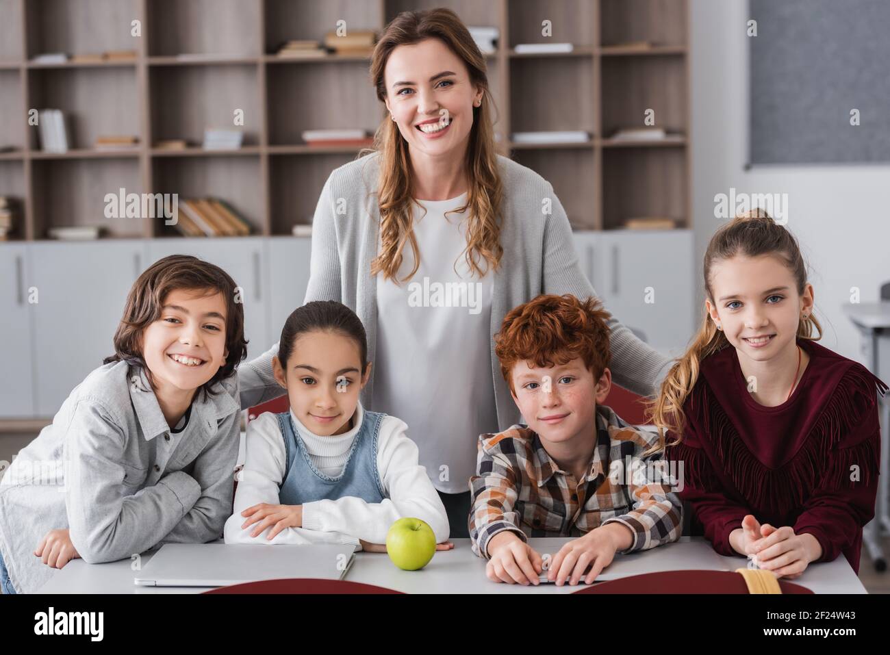 happy teacher and cheerful kids looking at camera in school Stock Photo ...
