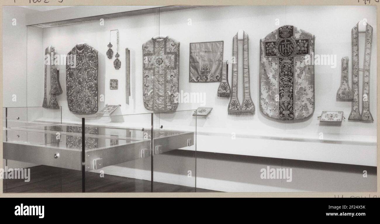 Church textiles in showcases, including kazuels and stoles; Presentation of religious textile in room 166.in the middle a kazuifel from yellow silk satin with embroidery, to the left of the right cavity a stole of the lady material Stock Photo