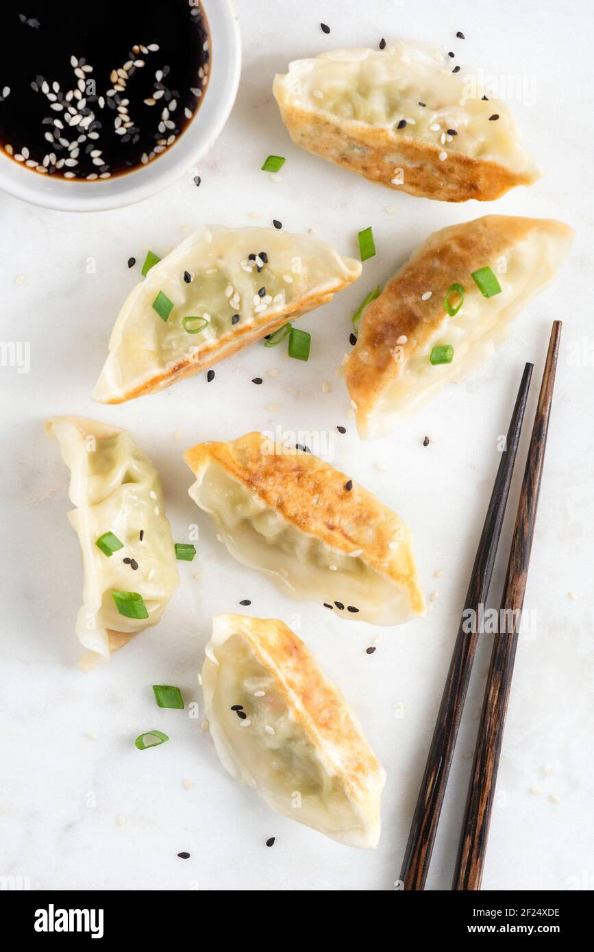Fried gyoza chinese meat dumplings served with dipping soy sauce. Top