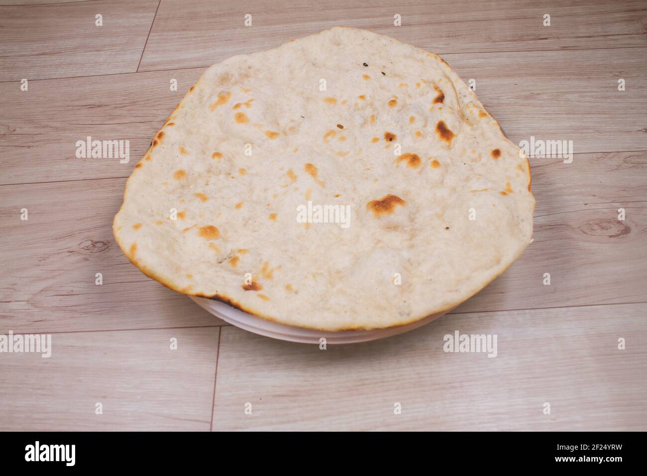 https://c8.alamy.com/comp/2F24YRW/indian-special-flat-bread-also-known-as-tandoori-roti-or-naan-served-in-a-white-ceramic-quarter-plate-2F24YRW.jpg