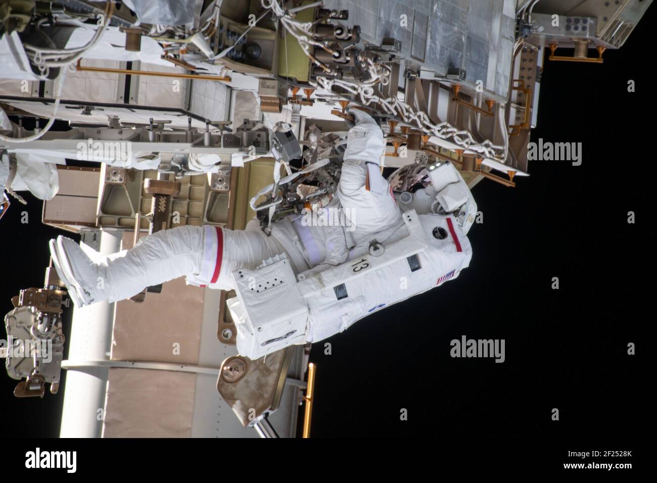 NASA astronaut Kate Rubins during a second spacewalk to install solar array modification kits on the International Space Station March 5, 2021 in Earth Orbit. The maintenance work will support new, more powerful solar arrays that will be delivered on upcoming SpaceX Dragon cargo missions. Stock Photo