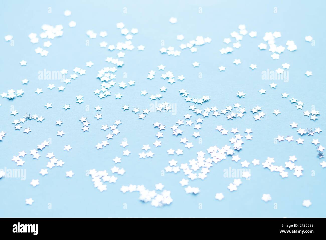 Silver shiny stars glitter or confetti on light blue background Stock Photo Alamy