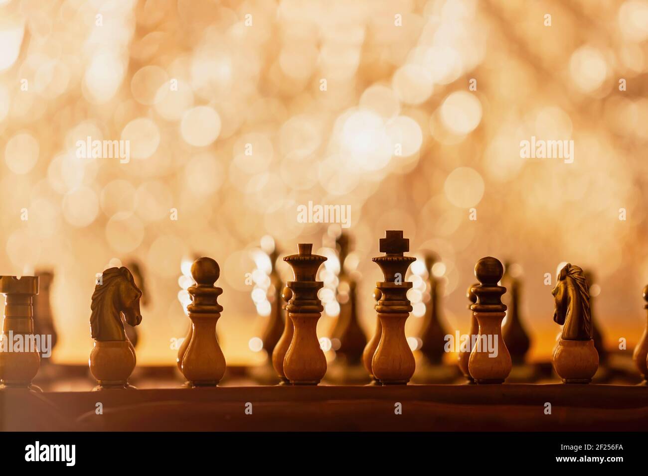 Chess pieces placed on chess board, beginning of game. Abstract shining  background with bokeh, copy space Stock Photo - Alamy