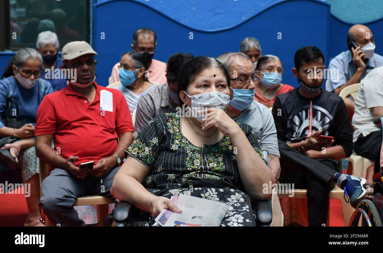 Elderly people wearing face masks wait inside a room after getting vaccinated.After Covid-19 vaccination of healthcare and frontline workers, vaccination drive has been initiated to cover citizens above 60 years and above 45 years of age suffering from comorbid conditions. Stock Photo