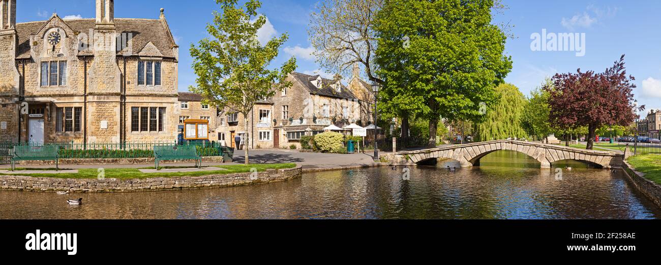 An early morning panoramic view of the River Windrush flowing through the Cotswold village of Bourton on the Water, Gloucestershire UK Stock Photo