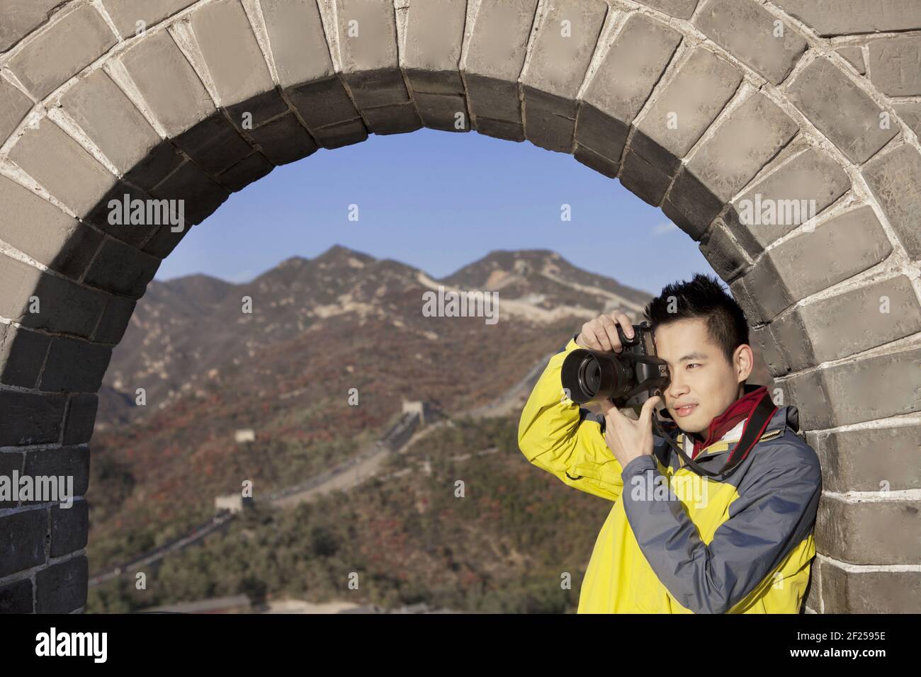 A young man to take photos in the the Great Wall Tourism Stock Photo