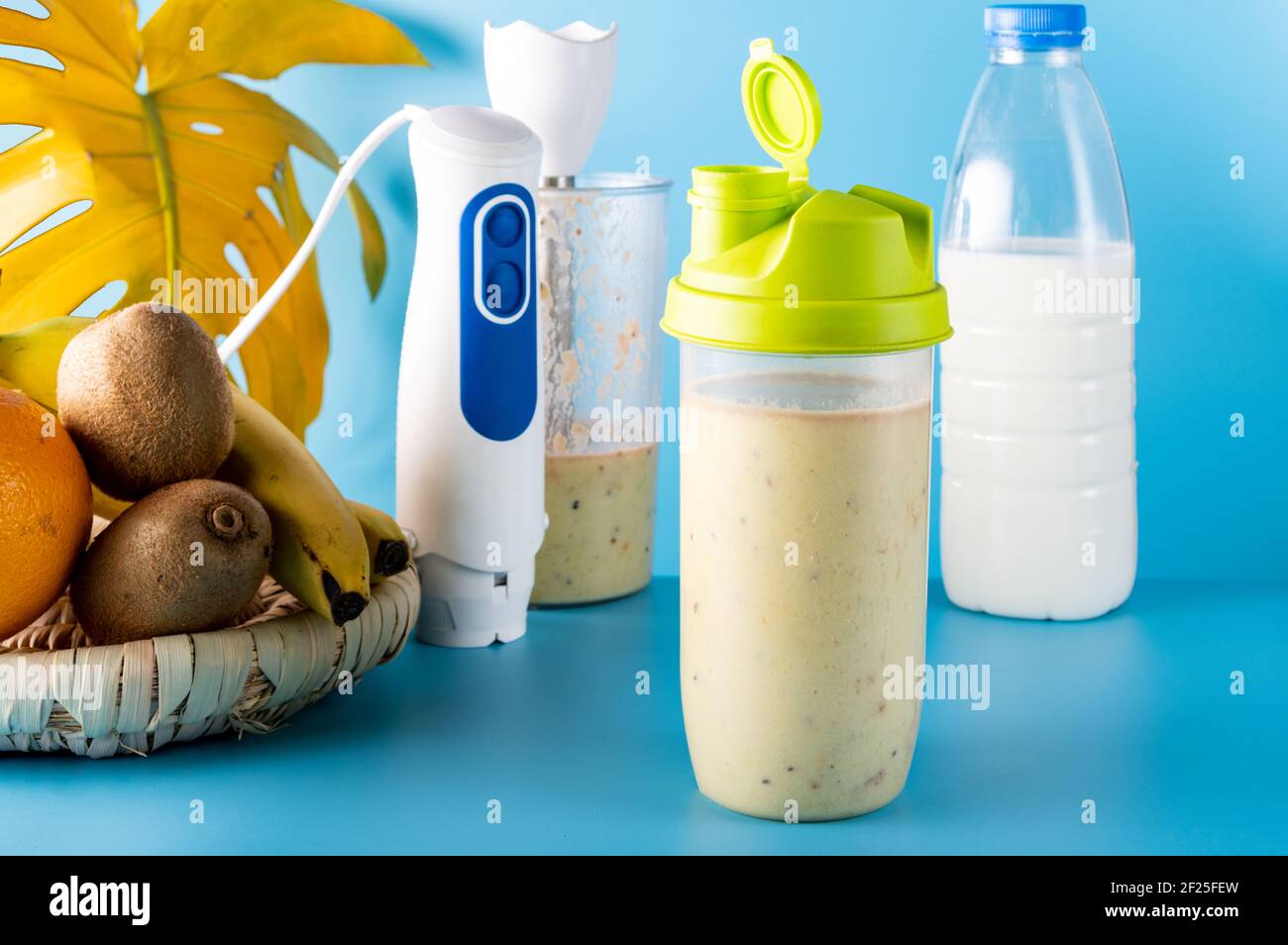 Freshly prepared protein shake made from fruit and milk. Blue background. Stock Photo