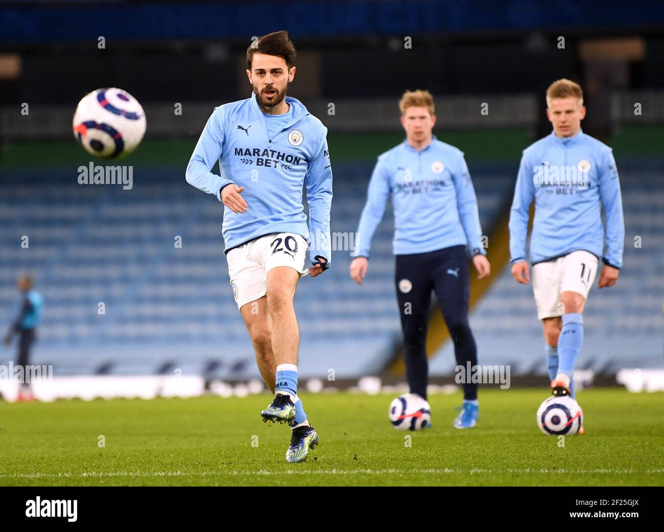 Manchester City's Bernardo Silva (left) warms up on the pitch ahead of the Premier League match at the Etihad Stadium, Manchester. Picture date: Wednesday March 10, 2021. Stock Photo