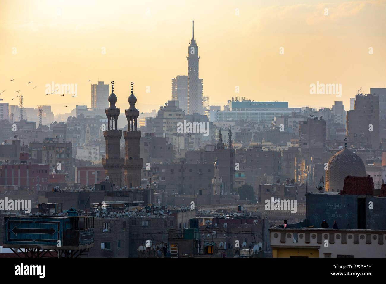 Atmospheric Cairo cityscape at sunset showing Cairo Tower and minarets, as seen from Al Azhar Park, Salah Salem St, El-Darb El-Ahmar, Cairo, Egypt Stock Photo