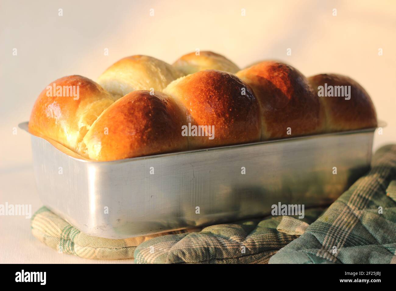 Freshly Home baked Brioche bun loaf inside the loft tin. Shot on white