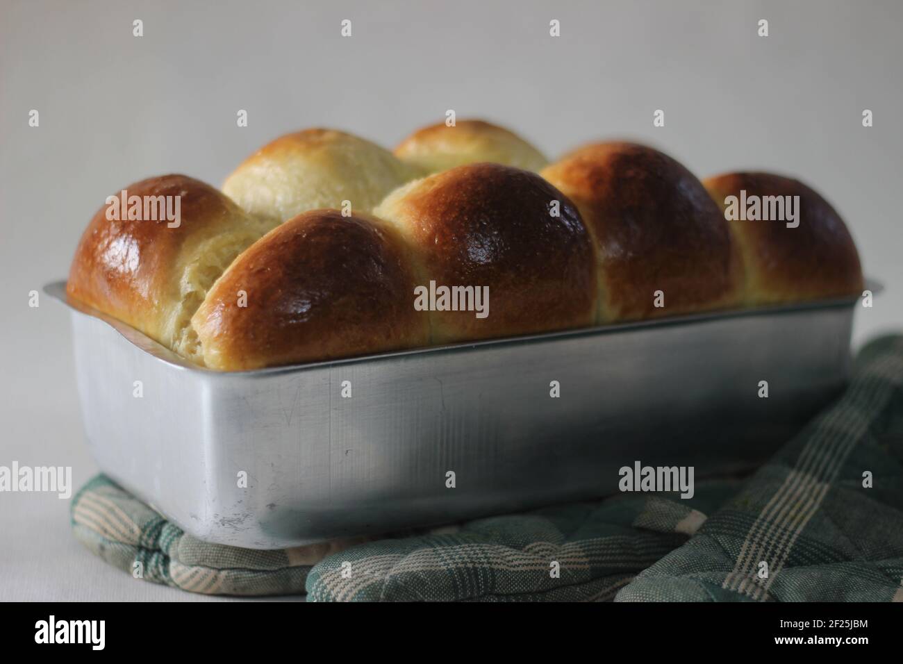 Freshly Home baked Brioche bun loaf inside the loft tin. Shot on white