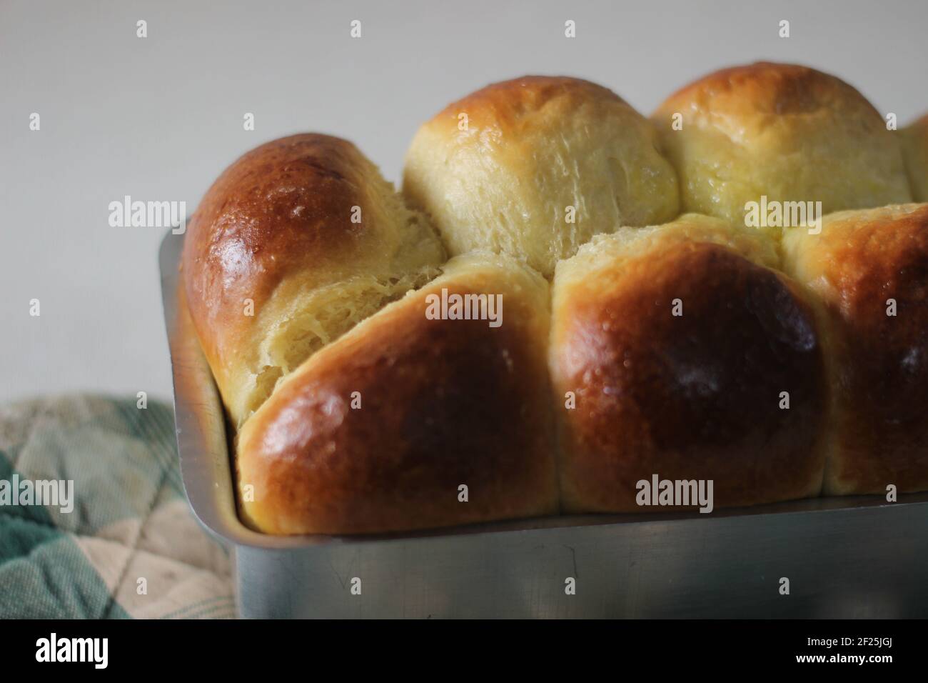 Freshly Home baked Brioche bun loaf inside the loft tin. Shot on white