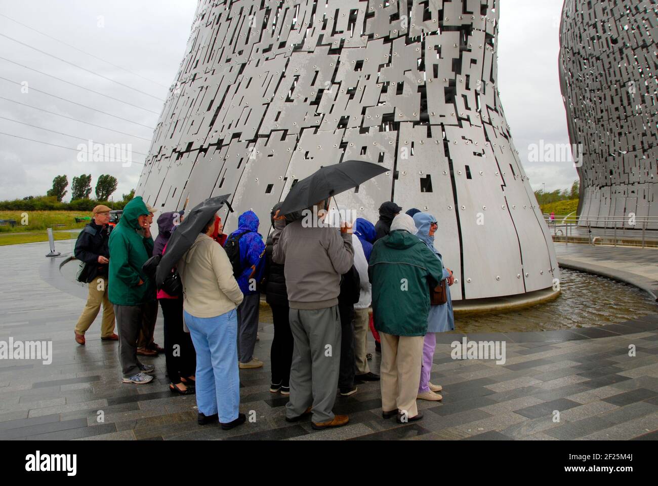 Group of elderly people visiting the Kelpies on a wet day, the Helix, Falkirk, Scotland Stock Photo