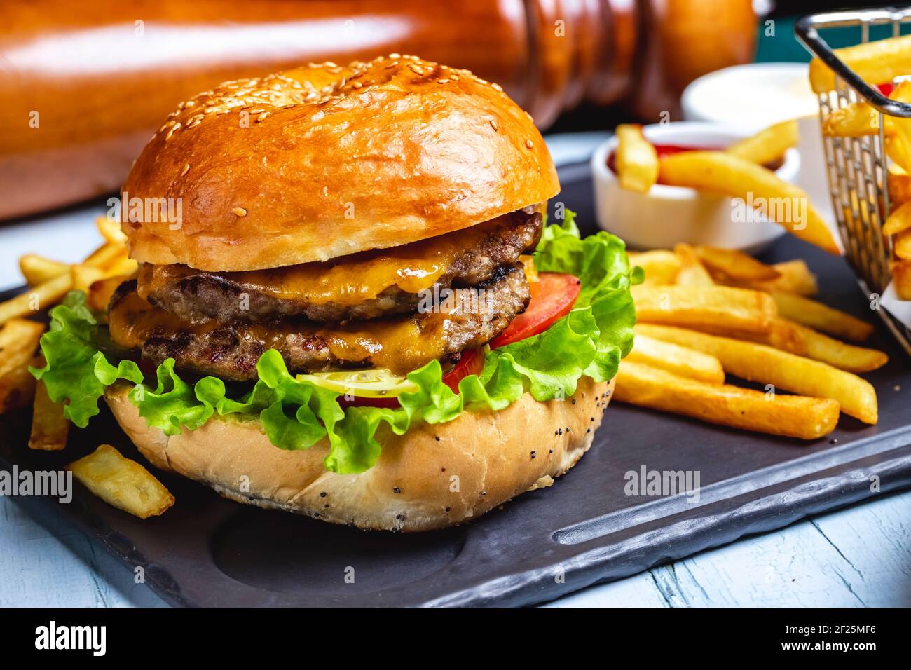 beef burger meat lettuce tomato cheese french fries side view Stock