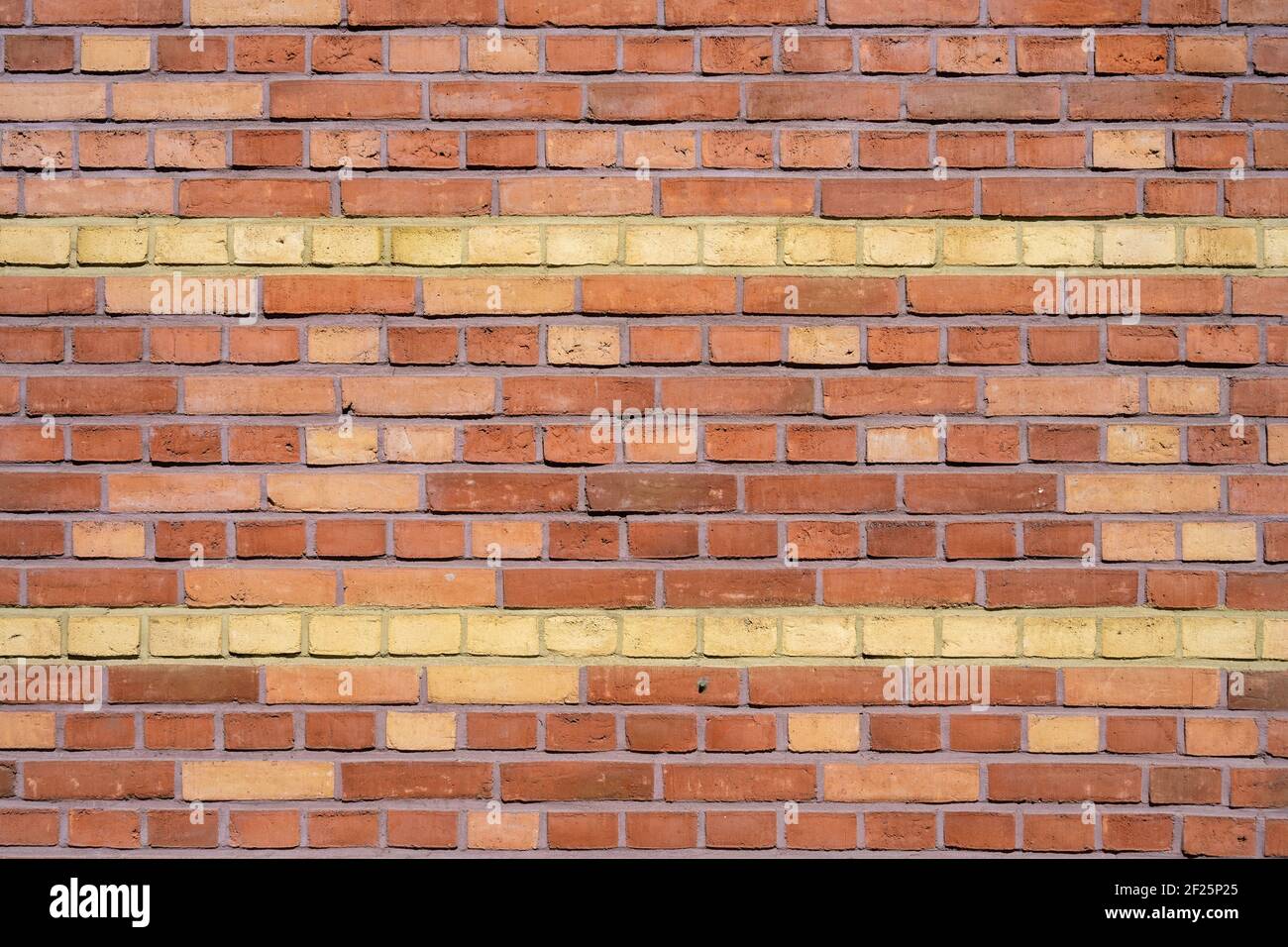 Background from a red brick wall with yellow stripes Stock Photo