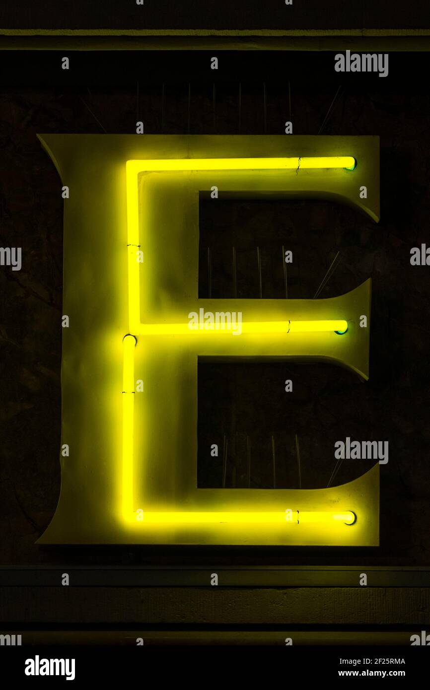 Glowing yellow neon letter E Stock Photo