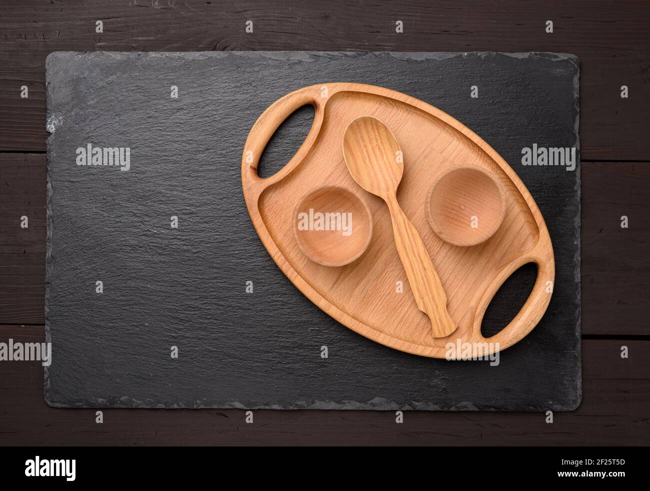 Empty oval brown wooden tray board on a black background Stock Photo
