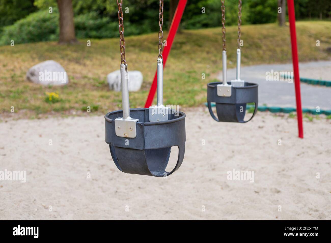Swings in the park at playground on a summer day without people Stock Photo