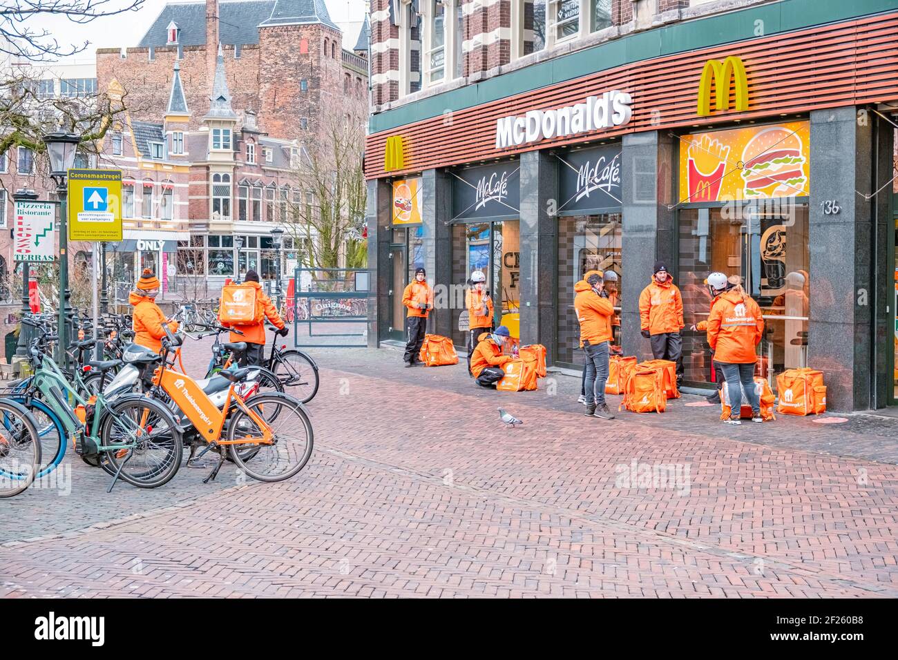 Utrecht Netherlands Thuisbezorgd and Deliveroo food couriers wait in Utrecht, Netherlands. Bicycle food delivery is popular in U Stock Photo
