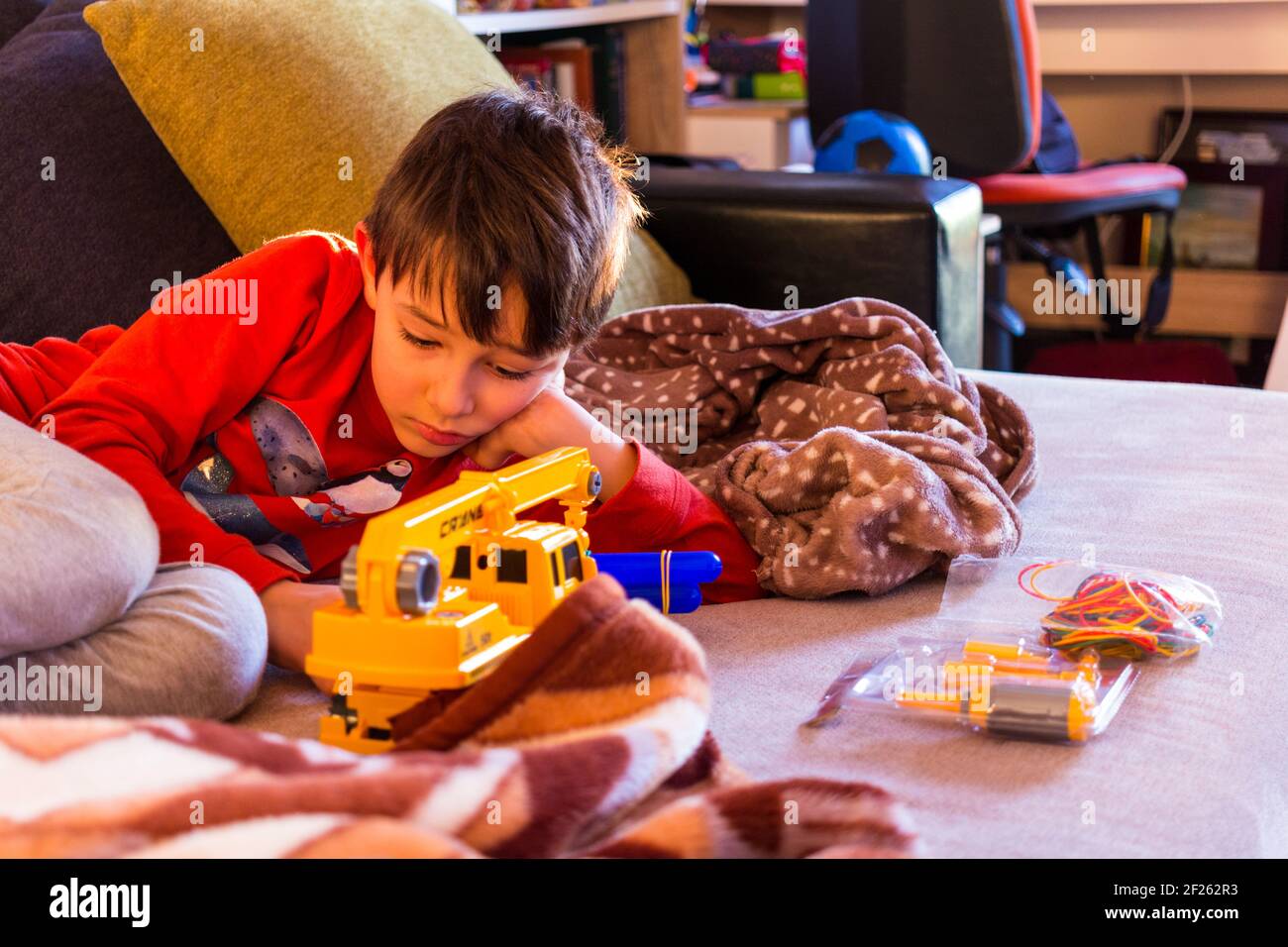Boy child playing with toy car on sofa at home Stock Photo - Alamy