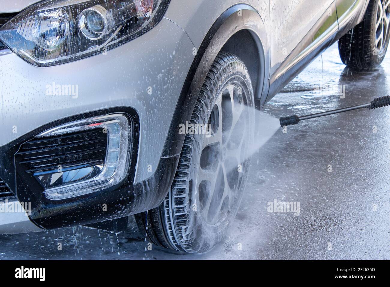 Car wash on a contactless car wash. A man washes the car. Put the car