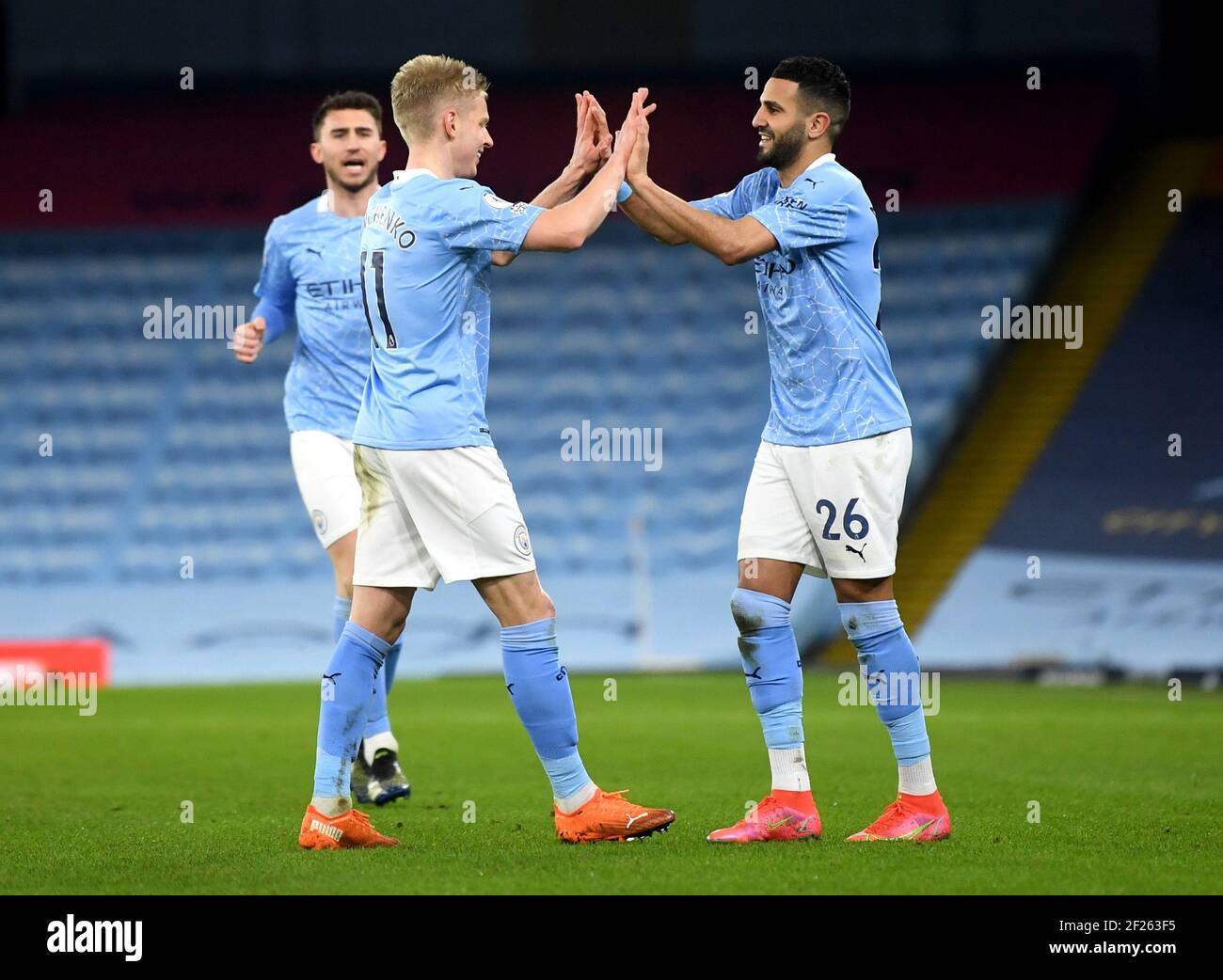 Manchester City's Riyad Mahrez (right) celebrates scoring their side's fourth goal of the game during the Premier League match at the Etihad Stadium, Manchester. Picture date: Wednesday March 10, 2021. Stock Photo